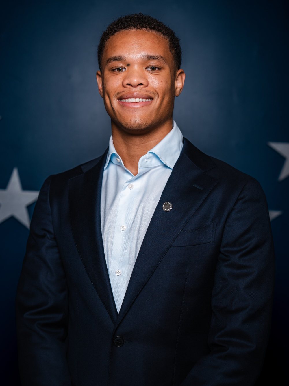 Mekhi Simpson, smiling, in a navy blazer